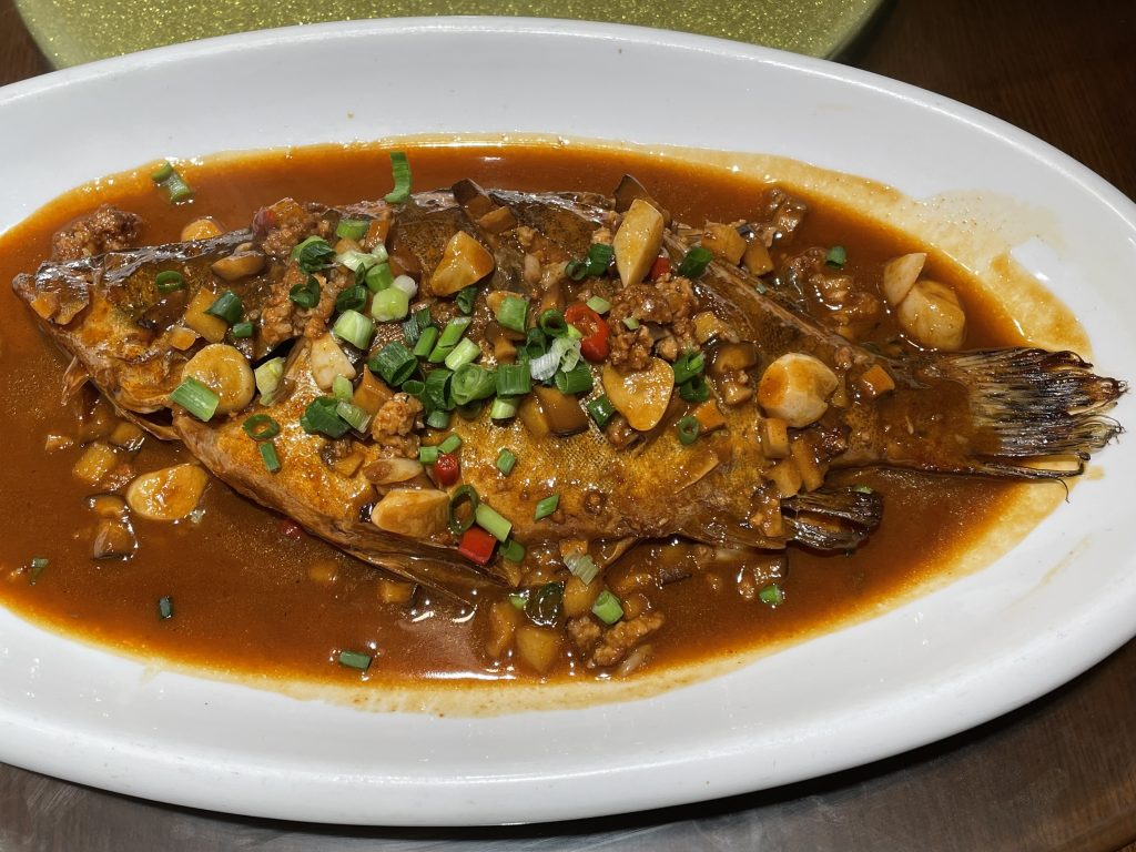 Plate of Anhui fermented mandarin fish in red sauce with chillies and aromatics