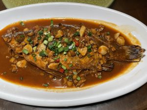 Plate of Anhui fermented mandarin fish in red sauce with chillies and aromatics