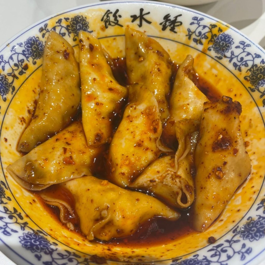 Plate of Chengdu Zhong dumplings coated in red chilli oil