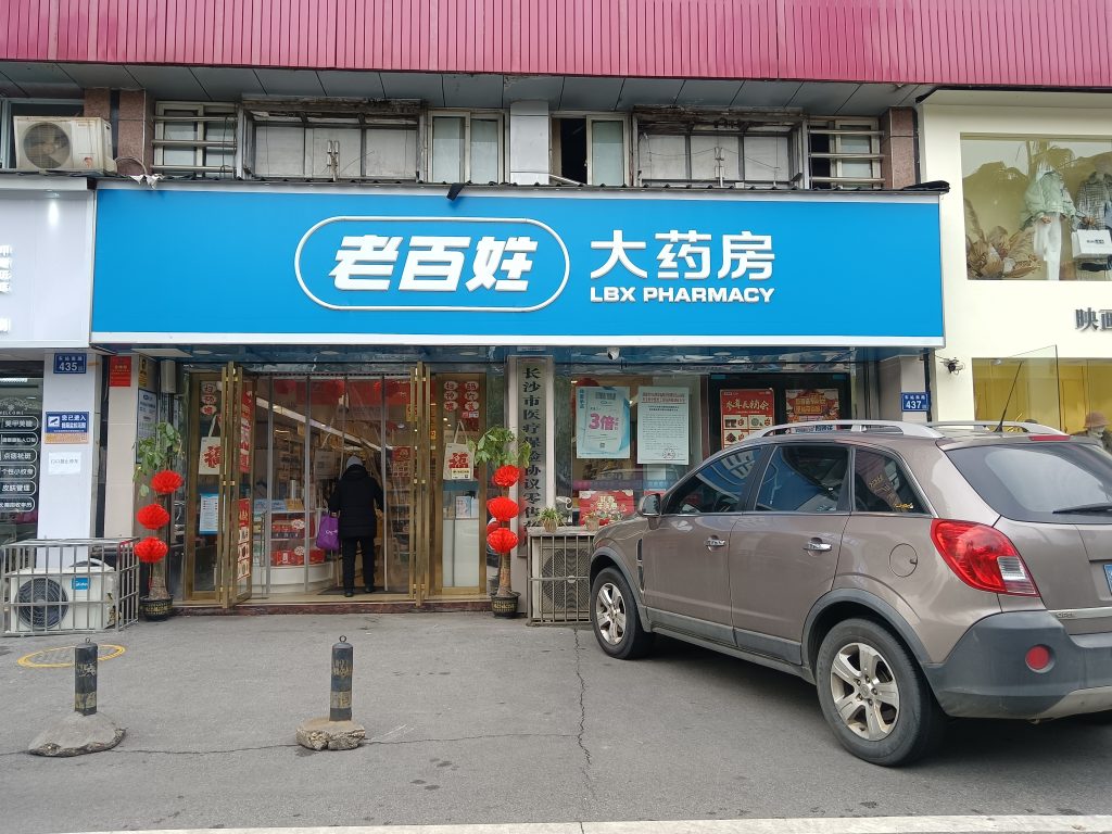 Storefront of an LBX Pharmacy branch with green signage on a city street in China