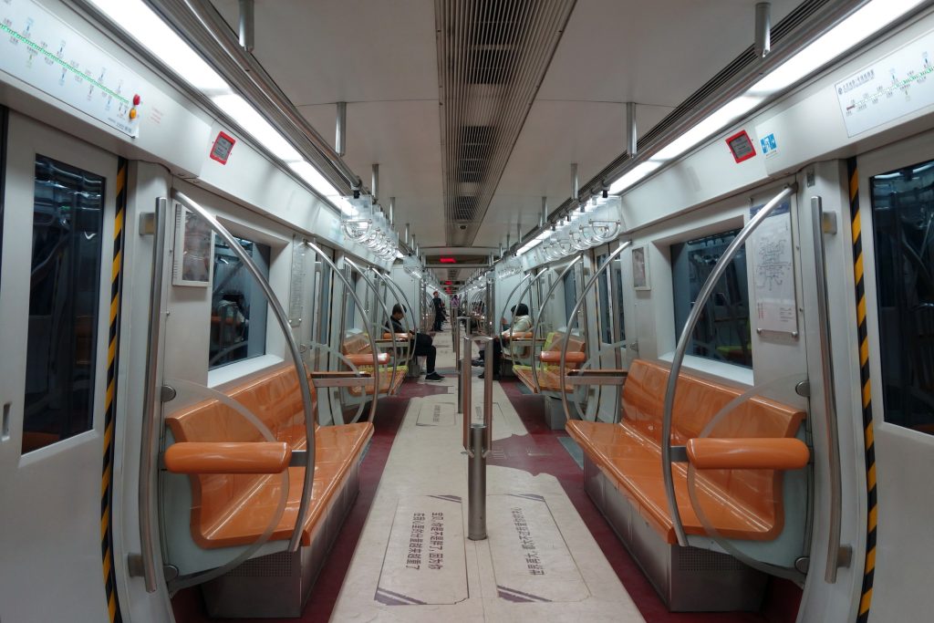 Interior of a Beijing Subway Line 1 train carriage with seats and handrails