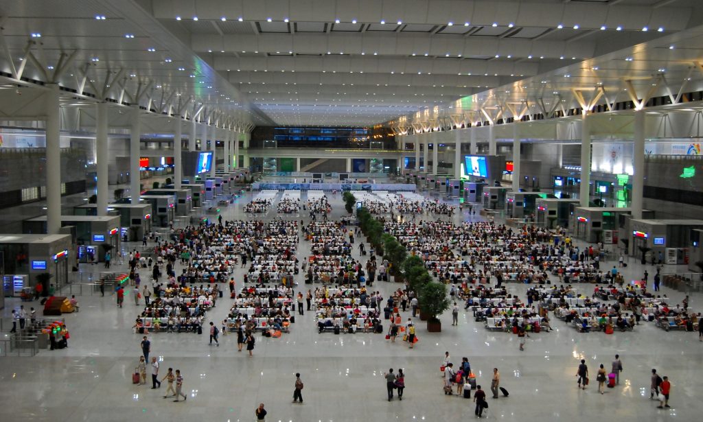 Waiting hall interior of Shanghai Hongqiao Railway Station with passengers and departure boards