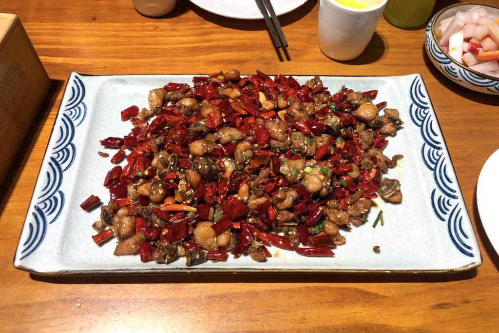 Plate of Sichuan laziji spicy chicken with dried red chillies and chicken pieces