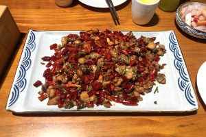 Plate of Sichuan laziji spicy chicken with dried red chillies and chicken pieces