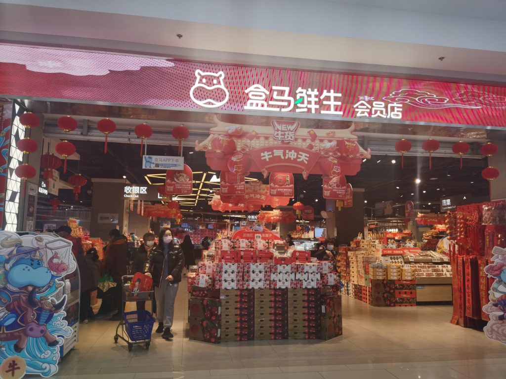 Interior of a Hema fresh supermarket with shopping carts and grocery shelves in China