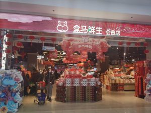 Interior of a Hema fresh supermarket with shopping carts and grocery shelves in China