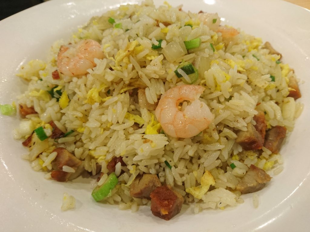 Plate of Yangzhou-style fried rice with egg, shrimp, and diced vegetables in a Hong Kong fast-food shop