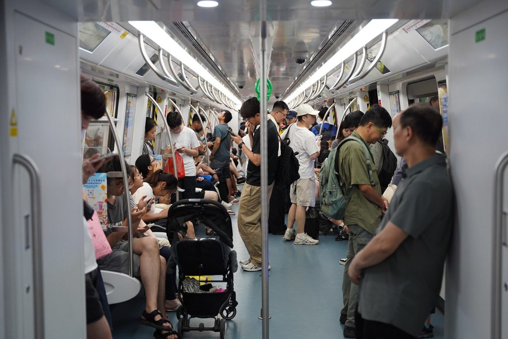 Commuters standing and sitting in a busy carriage on Line 2 of the Shenzhen Metro