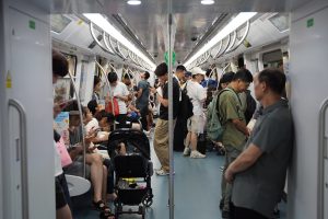 Commuters standing and sitting in a busy carriage on Line 2 of the Shenzhen Metro
