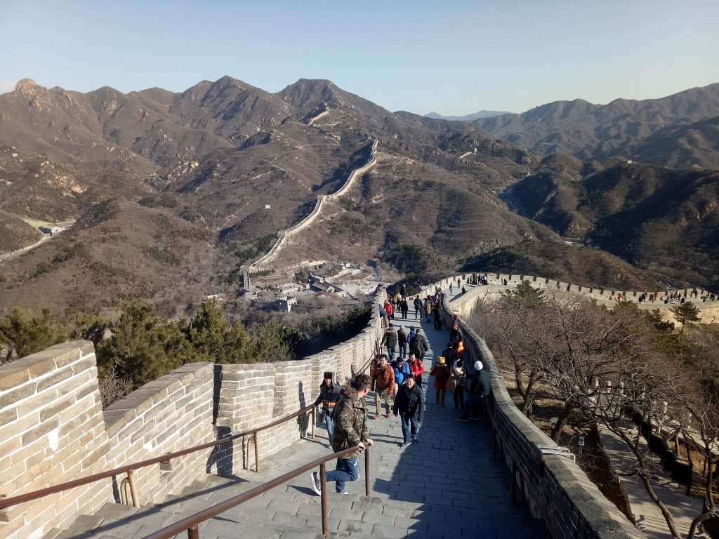 Visitors on the stone ramparts of Badaling Great Wall winding through late-autumn hills near Beijing