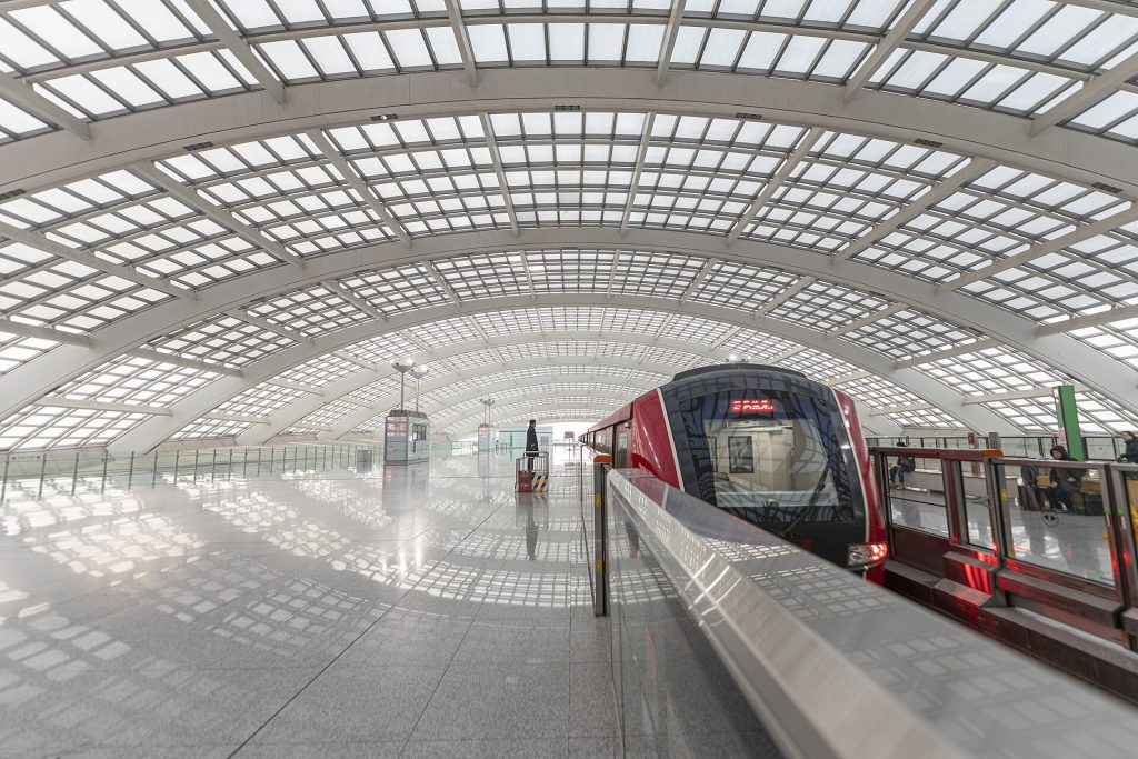Modern Beijing airport terminal exterior and roadway under clear sky