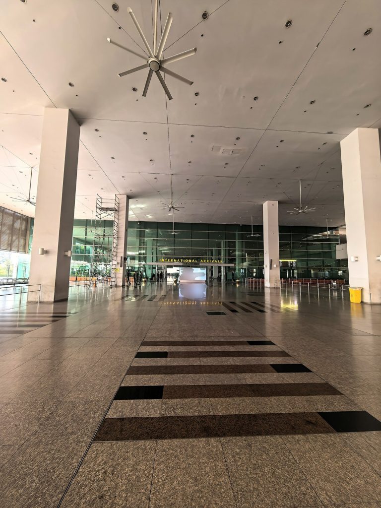 Travellers with luggage walking through an international airport arrivals hall