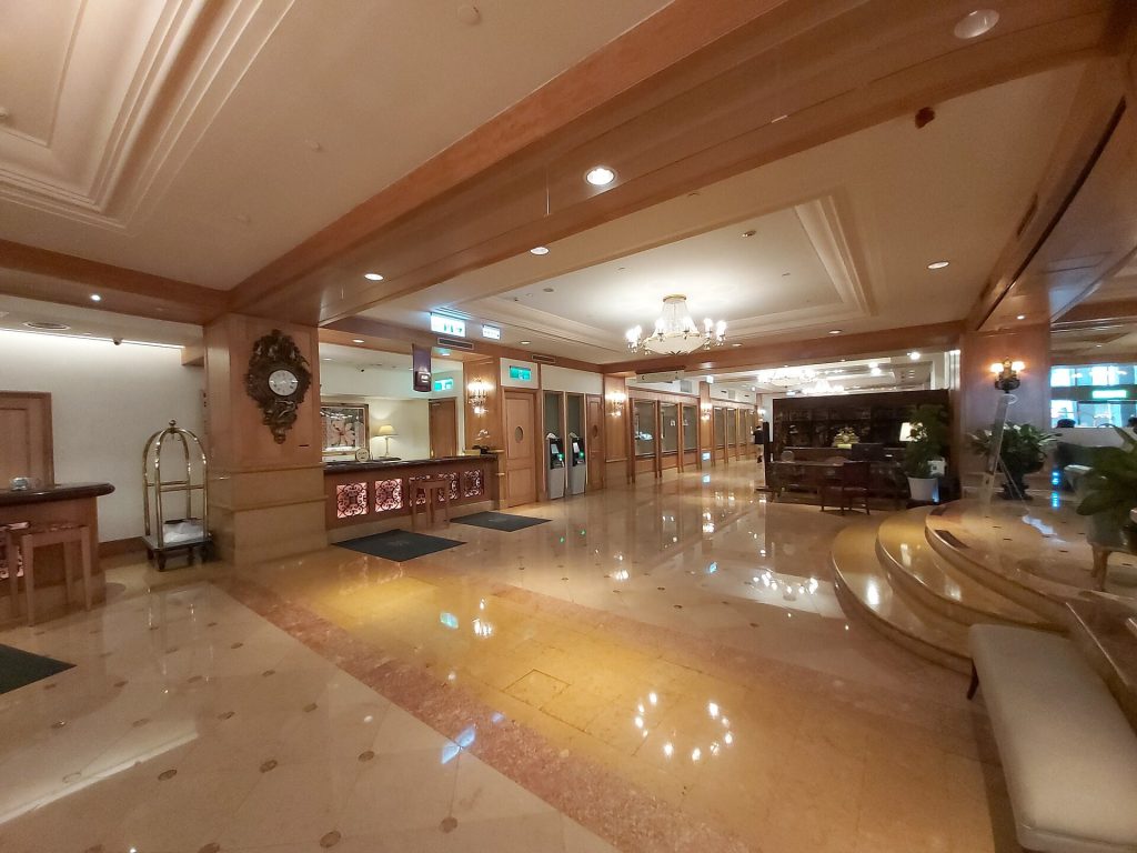 Hotel front desk scanning a foreign passport during evening check-in