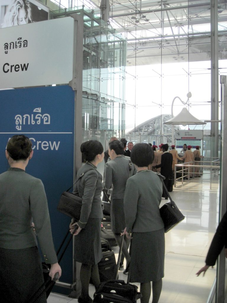 Travellers waiting in an international arrivals immigration queue with passports