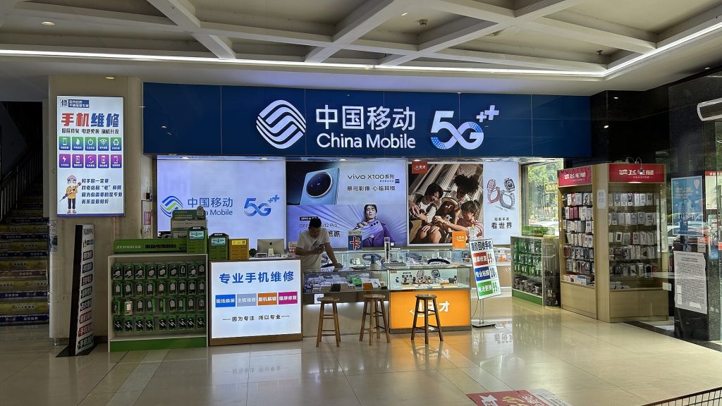 Airport mobile phone carrier kiosk with SIM card display and staff