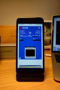Smartphone Alipay wallet screen next to a boarding pass