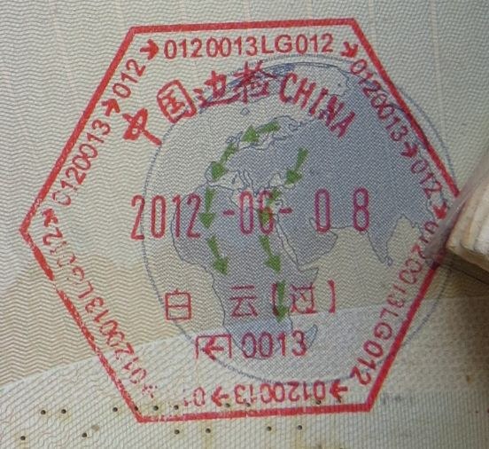 Traveller filling an immigration arrival card with passport on an airplane tray table