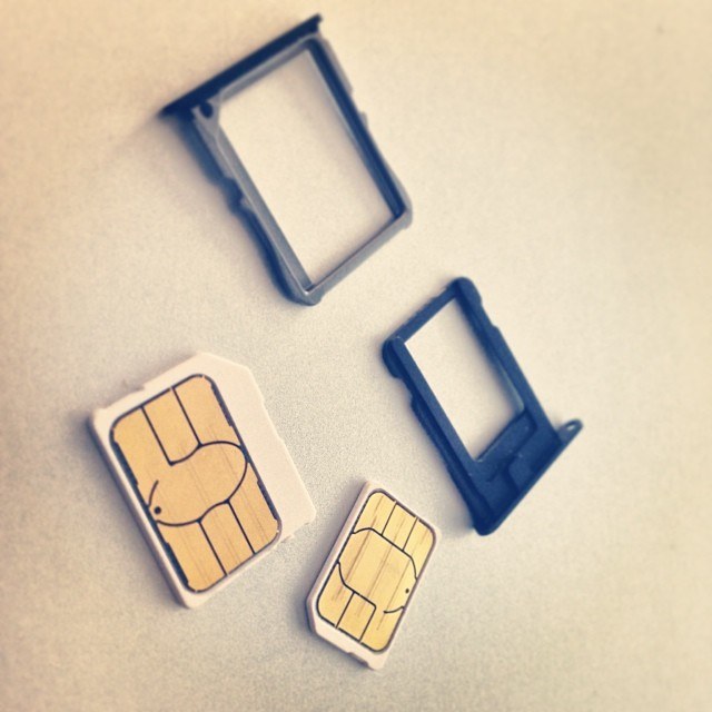Mobile phone SIM tray and eSIM activation screen on a travel desk