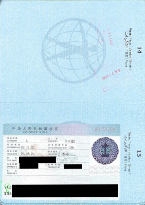 Passport open to China entry and exit stamp pages on an airport tray table