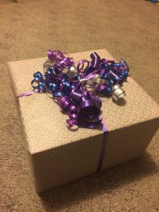 Wrapped gift box and fresh fruit arranged as a hostess gift on a table
