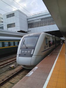 High-speed train platforms with passengers transferring with rolling luggage