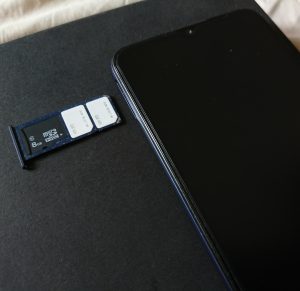 Smartphone SIM tray and tourist SIM packaging on an airport cafe table