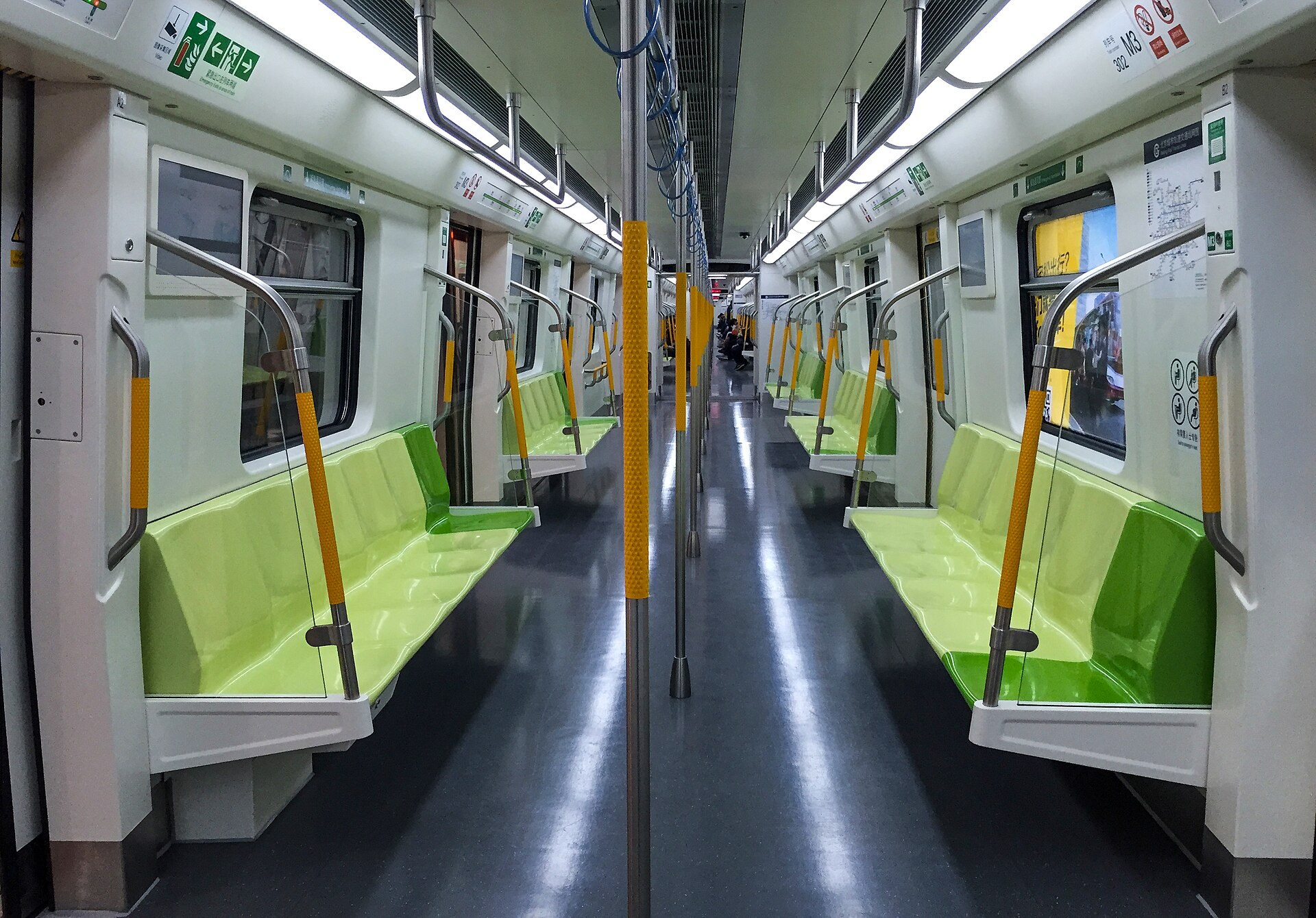 Metro carriage priority seating signs above seats with standing passengers nearby
