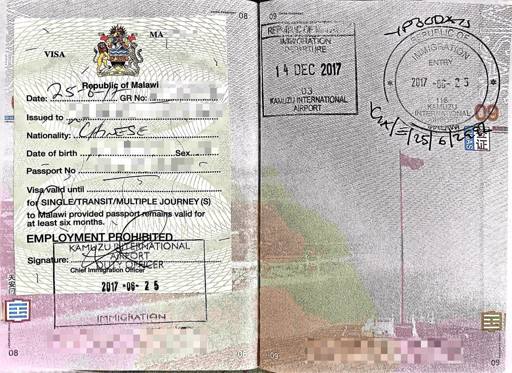 Chinese tourist visa stickers and passport pages on a travel desk