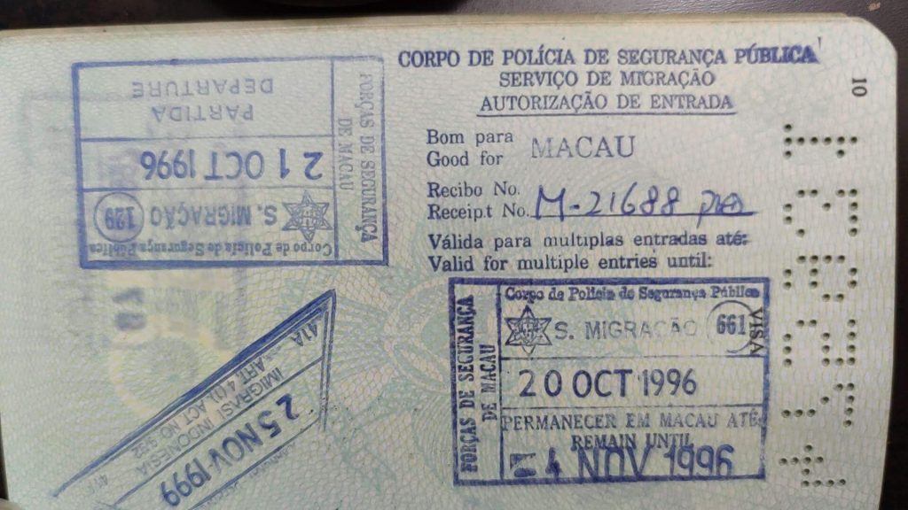 Passport stamp page open beside a boarding pass on an airport tray