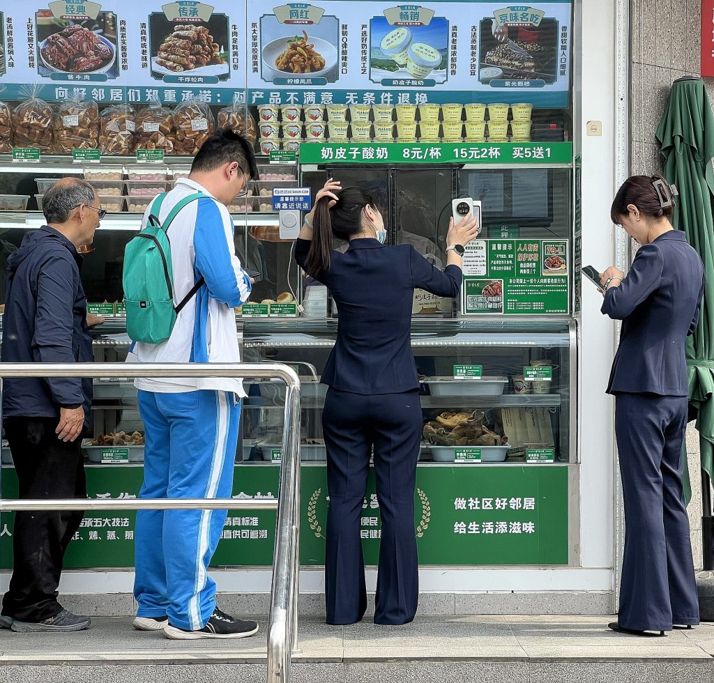 WeChat Pay wallet screen on a phone next to a foreign credit card