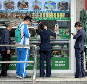 WeChat Pay wallet screen on a phone next to a foreign credit card