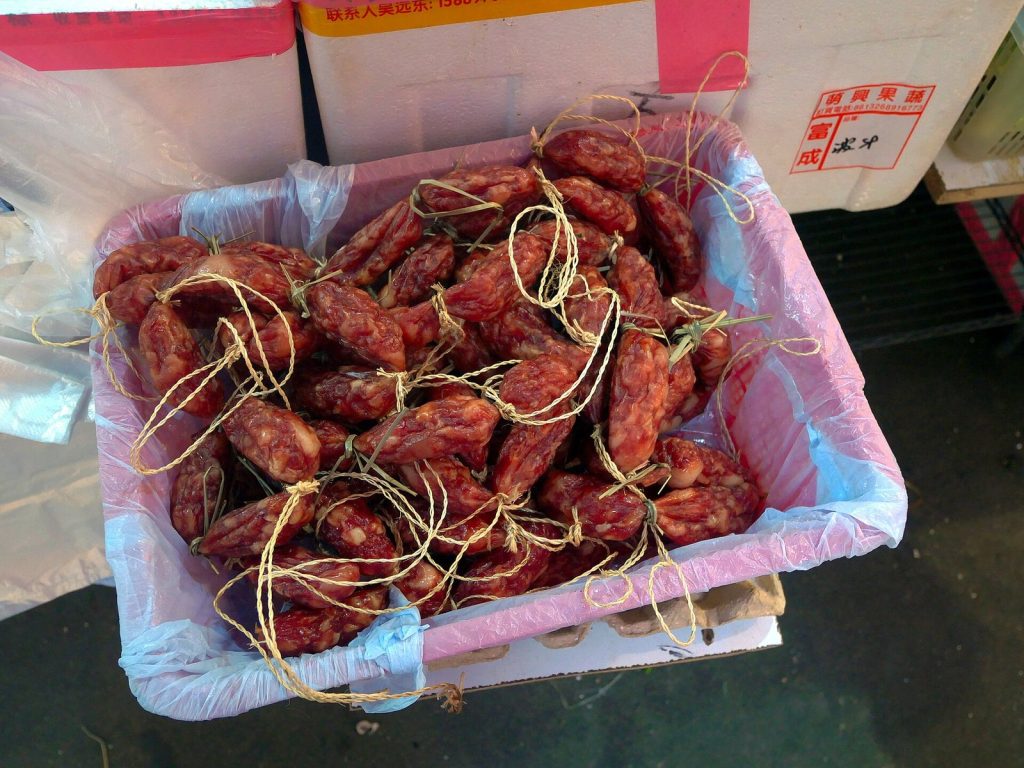 Basket of short, string-tied Cantonese-style Chinese sausages (lap cheong) at a market stall in Yuen Long, Hong Kong
