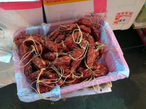 Basket of short, string-tied Cantonese-style Chinese sausages (lap cheong) at a market stall in Yuen Long, Hong Kong