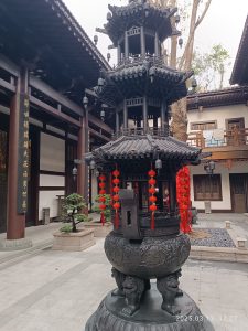 Incense smoke rising from a burner in a Chinese temple courtyard