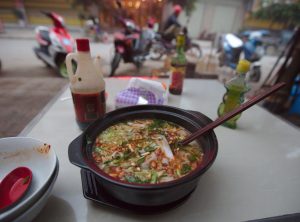 Bowl of Chongqing xiaomian noodles with chili oil, peanuts, and green onions