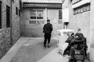 Quiet Beijing hutong alley with traditional courtyard walls and soft daylight