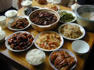 Table of Chinese dishes in Suzhou with bowls of rice, shrimp, eggplant, stir-fried vegetables, bamboo shoots and vegetarian duck