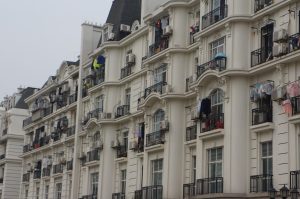 Laundry hanging out to dry on the balconies of a cream-coloured apartment building in China