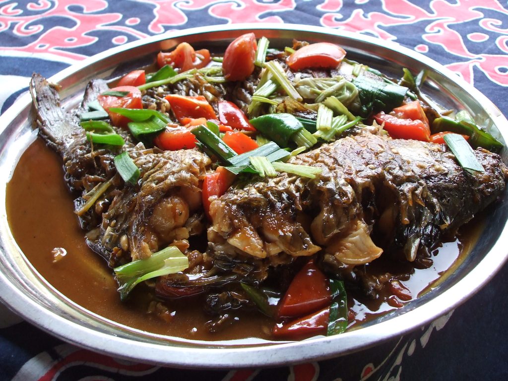 Plate of Guangxi-style beer fish (pijiu yu) with browned fish pieces in a savoury beer-based sauce