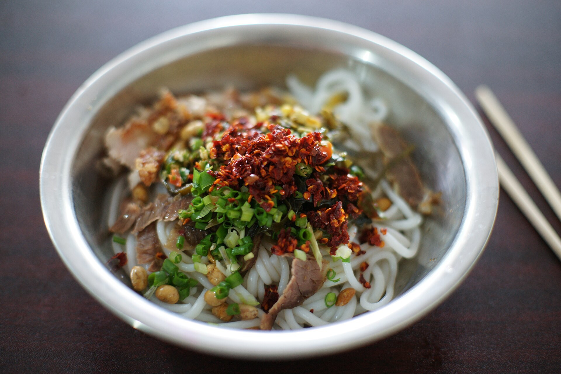 Bowl of Guilin rice noodles with pickled toppings and clear broth