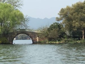 Hangzhou West Lake willow-lined causeway and water under soft daylight