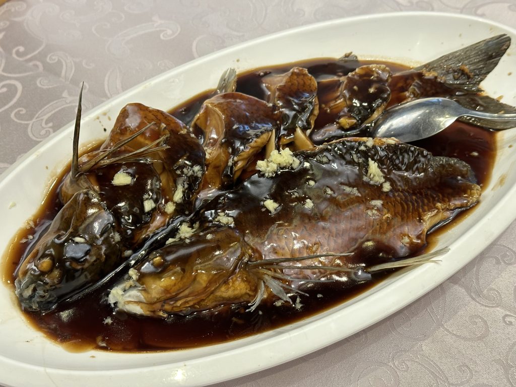 Plate of Hangzhou West Lake vinegar fish with whole fish in glossy sweet-sour vinegar gravy