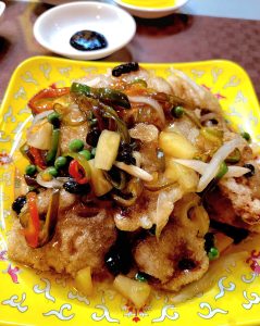 Plate of crispy sweet-and-sour pork with colourful vegetables