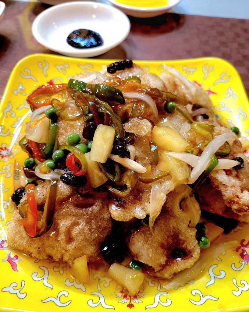 Plate of crispy sweet-and-sour pork with colourful vegetables