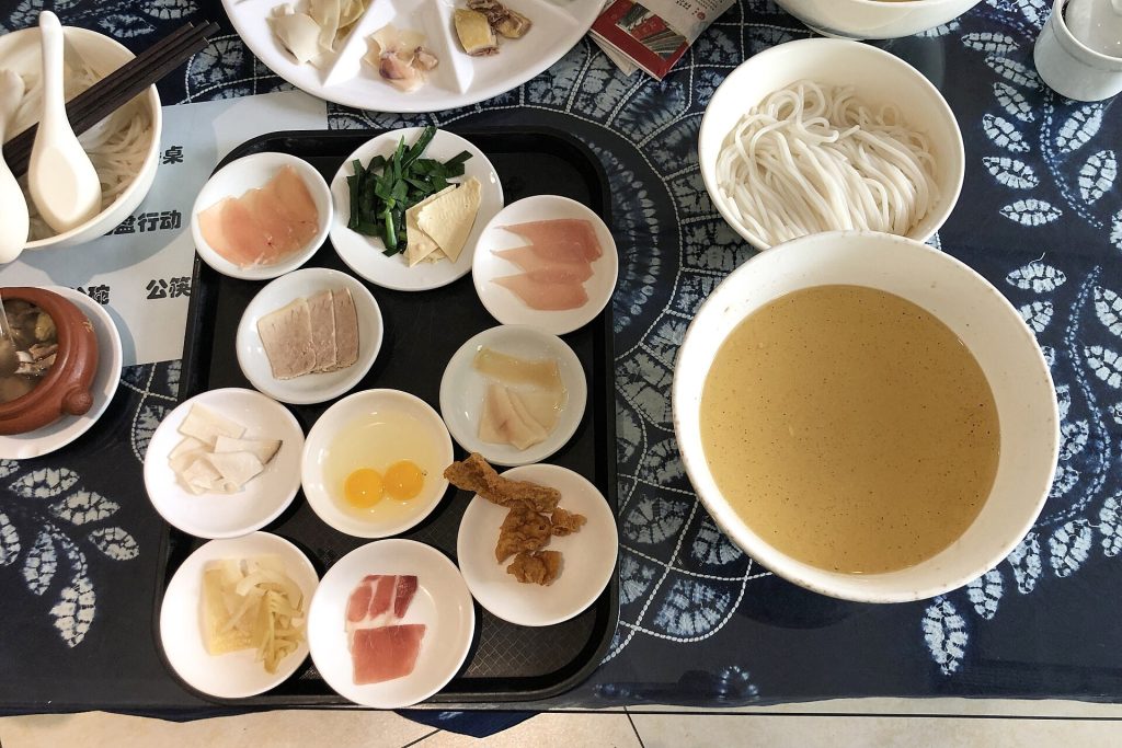 Bowl of Yunnan crossing-bridge rice noodles with toppings