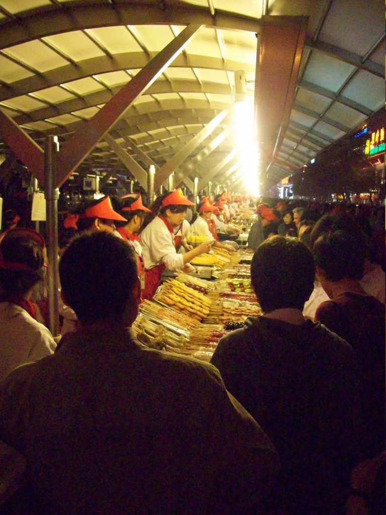 Food stalls and evening crowds at Donghuamen Night Market in Beijing