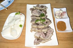 Plate of Northwest Chinese hand-grasped boiled lamb (shouzhuayangrou) with clear meat slices ready to eat by hand