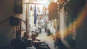 Narrow Shanghai lilong lane with brick houses and hanging laundry in soft afternoon light