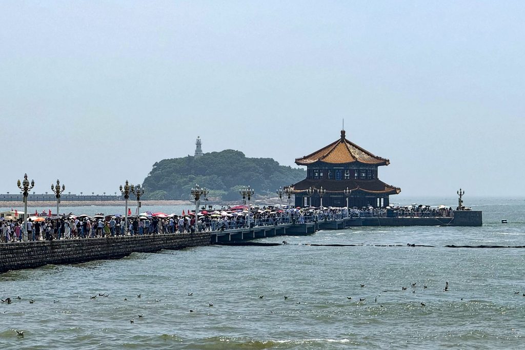 Qingdao seafront promenade at dusk with pier lights and calm autumn water