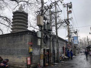 Quiet Beijing hutong lane with grey brick walls in morning light